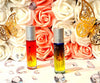 This picture includes 2 essential oil blends for pain. The glass rollerball bottles have a label for pain with the ingredients listed. The glass bottles are multi colored. The background has pink and white flowers with rhinestones on the bottom. There are also 2 gold butterflies there too. 